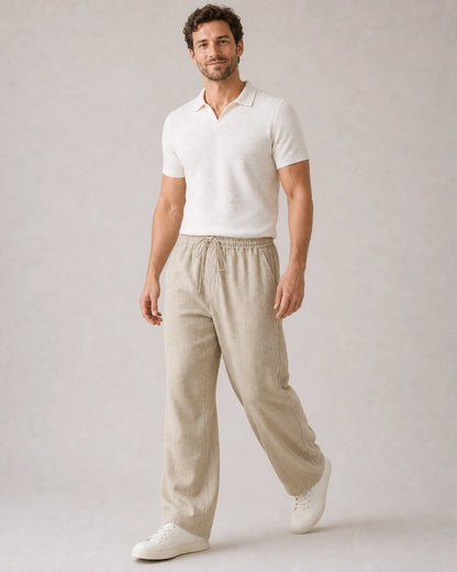 Man walking in beige linen wide-leg pants, showing movement and drape.
