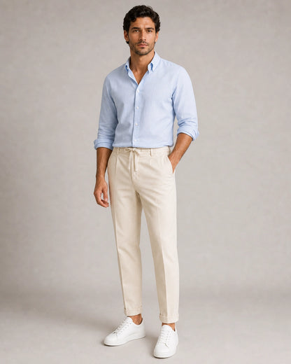 Men's beige tapered summer pants, alternate shirt and sneaker styling.