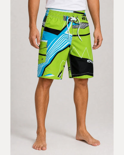Lime green and blue geometric knee-length swim shorts, front view.