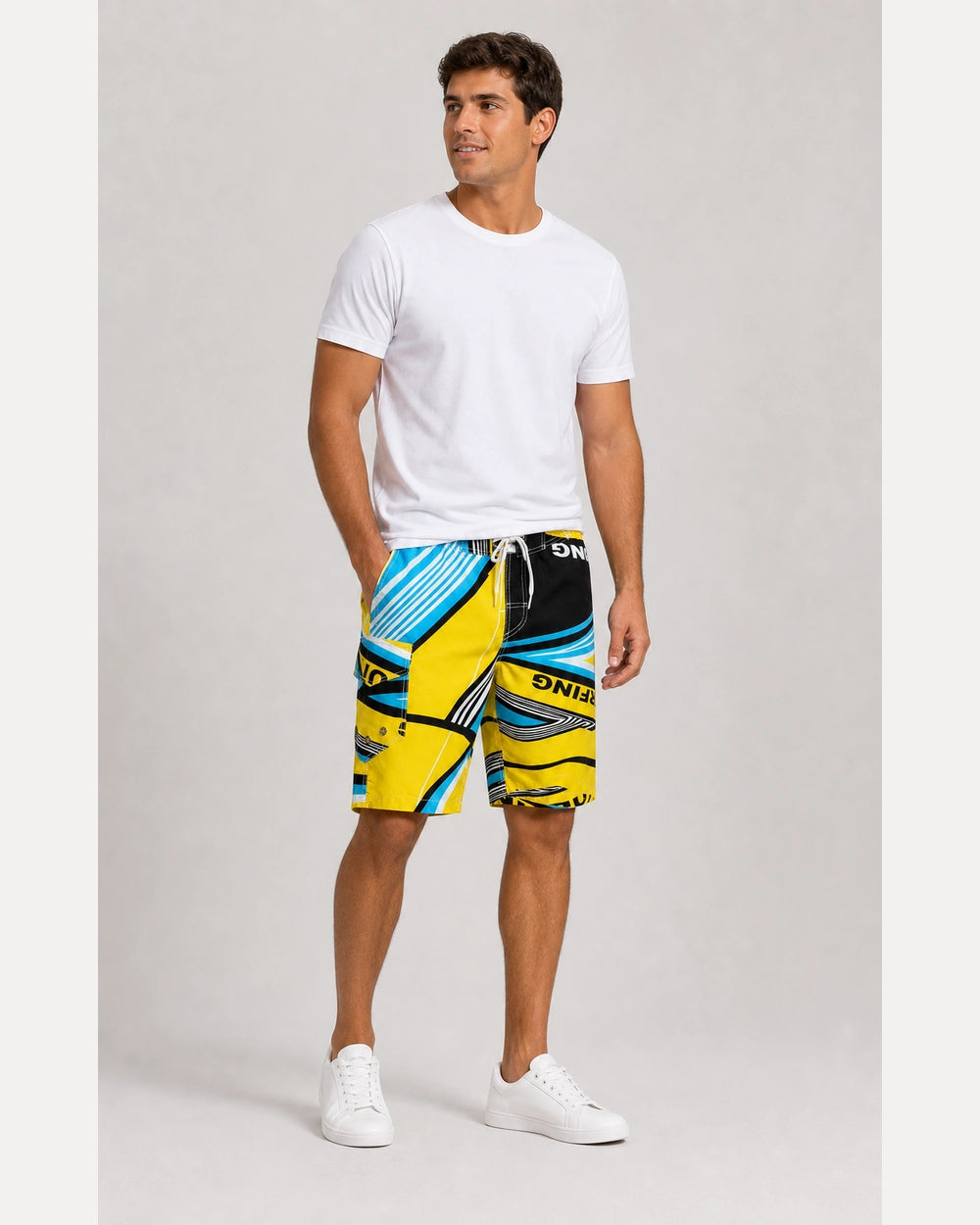 Man wearing blue and yellow geometric knee-length swim shorts in a complete styled look.