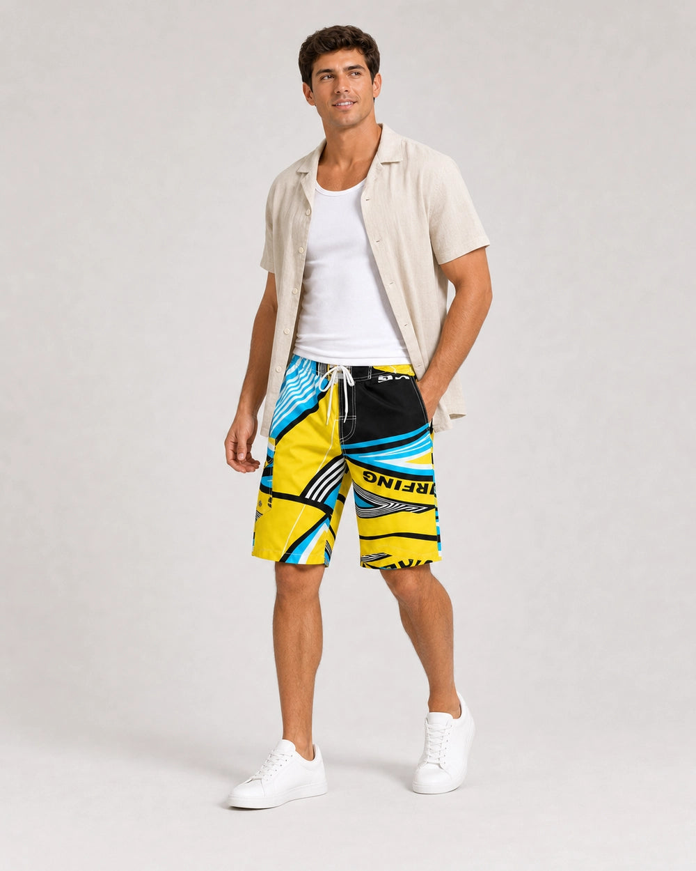 Man styling blue and yellow geometric knee-length swim shorts with a linen overshirt.