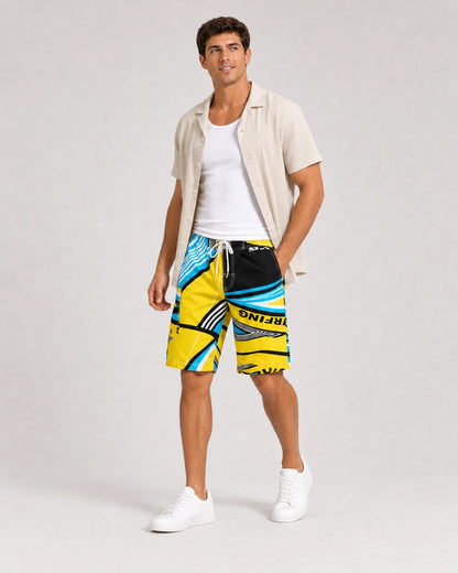 Man styling blue and yellow geometric knee-length swim shorts with a linen overshirt.