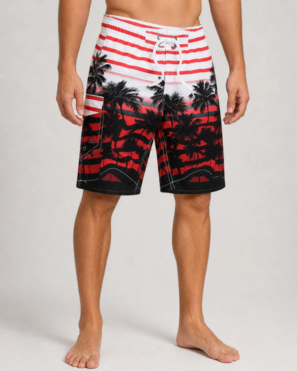 Red and black palm-print knee-length swim shorts, front view.